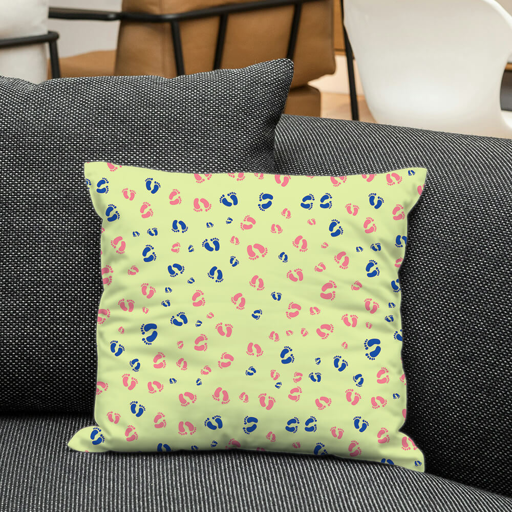 Cushion with blue and pink baby footprints on soft lime green, adding a cheerful and gender neutral nursery vibe.