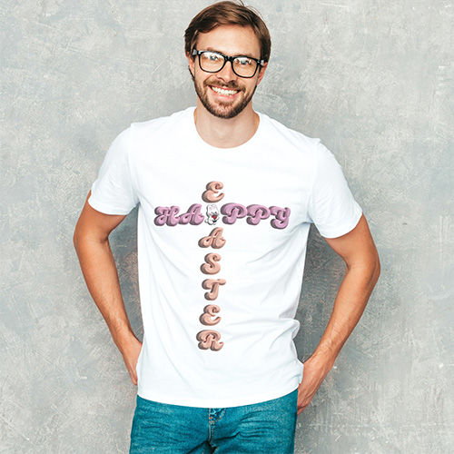 Smiling man wearing white T-shirt with “Happy Easter” cross design, standing against soft grey wall for a festive casual look.