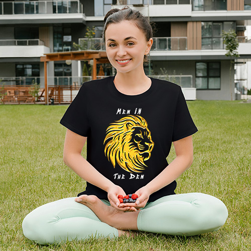 Lion graphic T-shirt design with bold yellow lion and subtle men in the den text expressing calm strength and confidence.